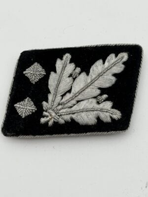 Original SS-Obergruppenführer collar tab 1942 pattern with hand-embroidered silver oak leaves and two rank pips.