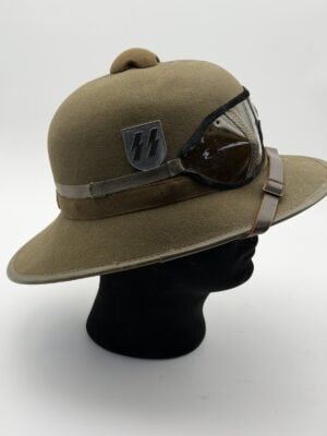 Waffen-SS tropical pith helmet second pattern front view; Waffen-SS Tropenhelm with Augenschützer 42 goggles; Waffen-SS tropical helmet SS runic shield; Waffen-SS Tropenhelm red swastika side shield; Second-pattern Waffen-SS pith helmet green underside; Waffen-SS tropical helmet red felt interior; Waffen-SS Tropenhelm leather sweatband and ventilation fitting; Original style Augenschützer 42 tinted tropical goggles.