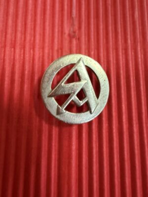 A membership stickpin showing the silver-coloured openwork emblem and circular border