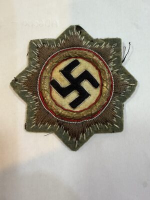 Cloth German Cross in Gold front showing embroidered starburst, metal wreath dated 1941 and field-grey backing.